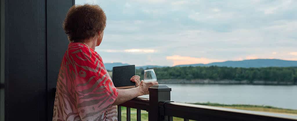 woman looking out across the lake and having some wine