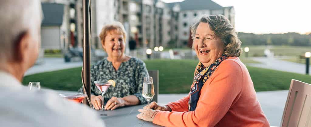 friends enjoying drinks and conversation on an outside patio at The Spires