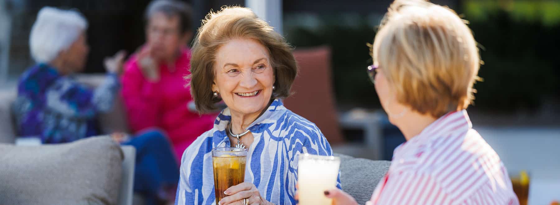 two elderly smiling outside
