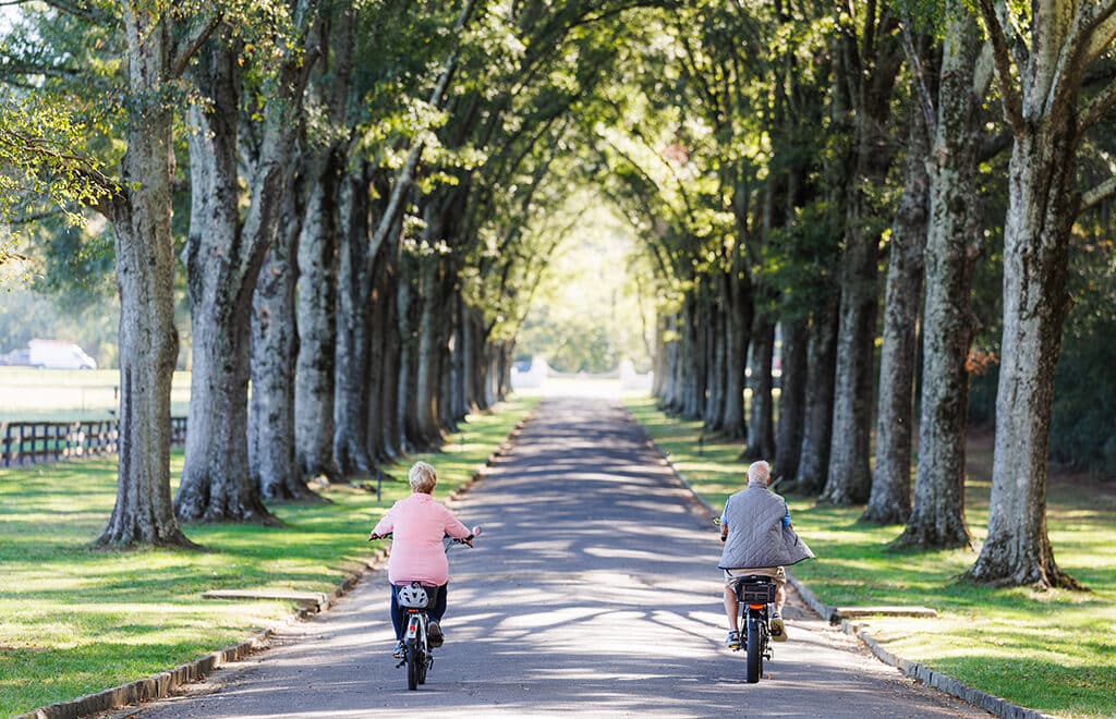 elderly couple riding bikes together